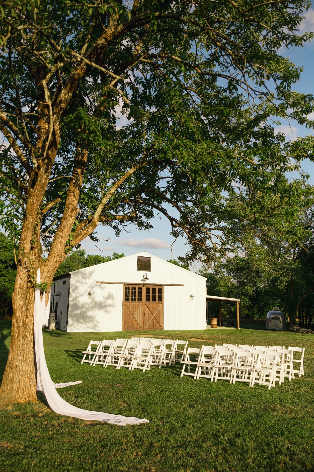 Ceremony seating facing the barn with the Airstream beyond