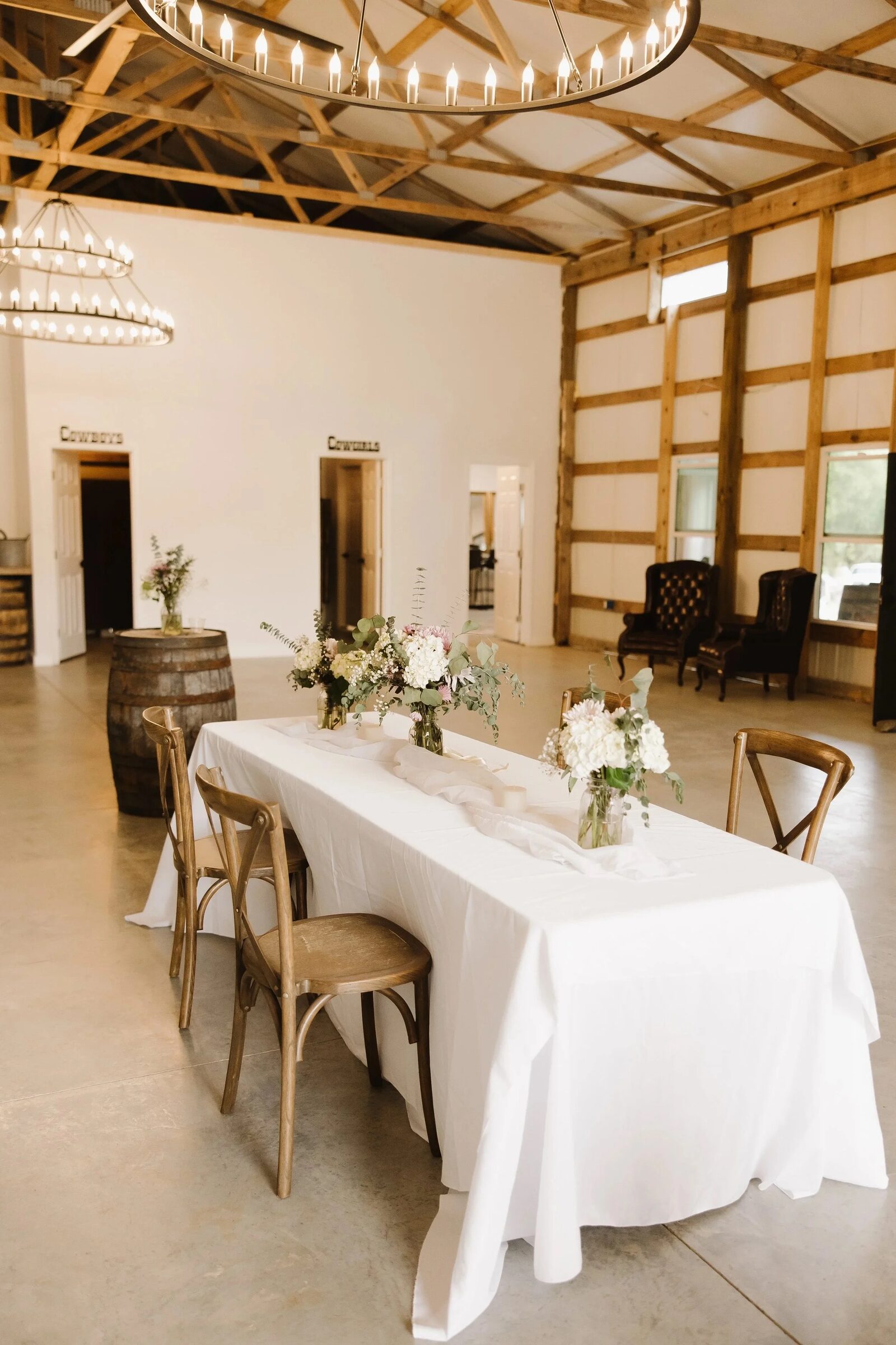 Reception table set with white linens, lanterns and centerpieces