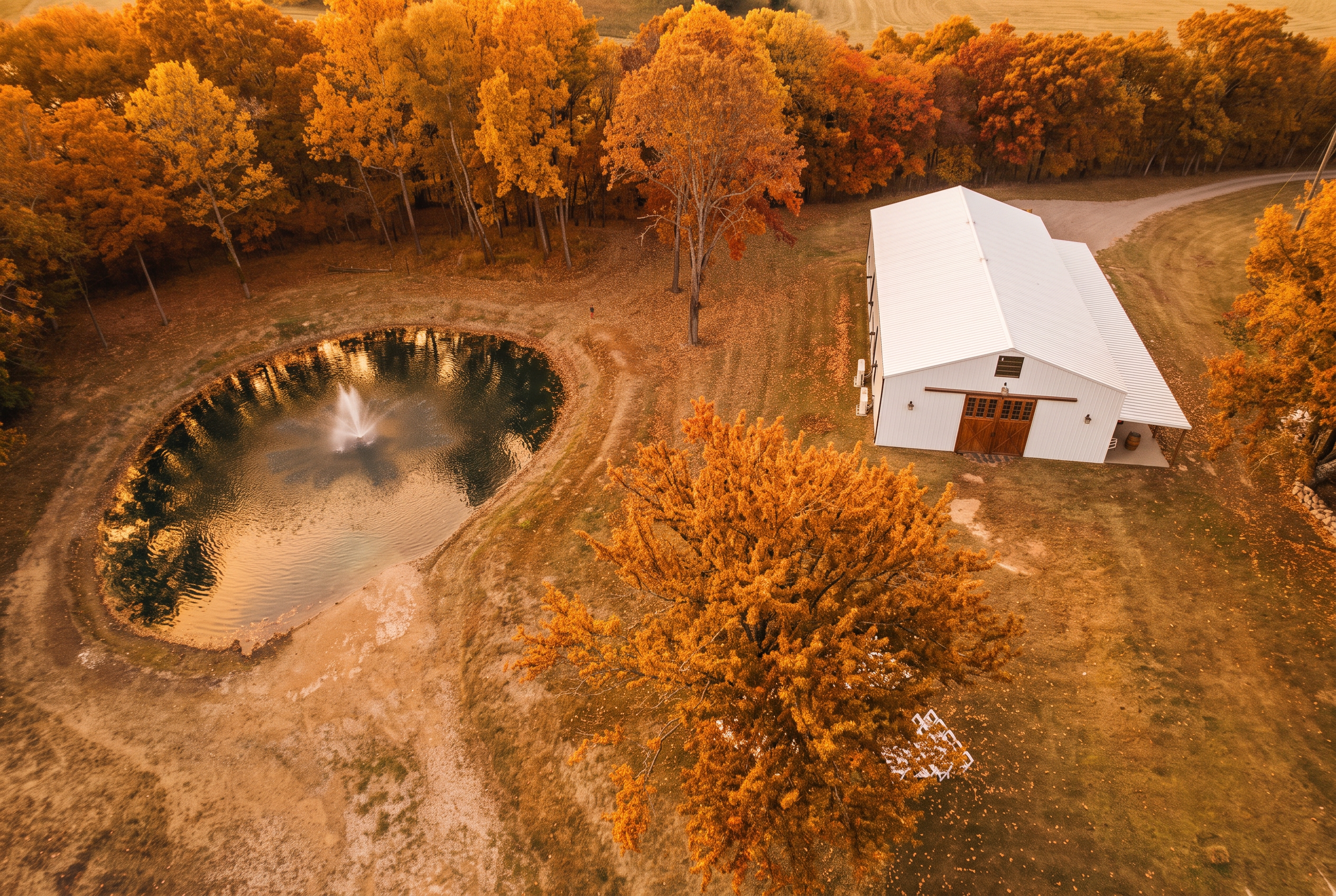 Aerial view of the ranch pond surrounded by peak autumn foliage