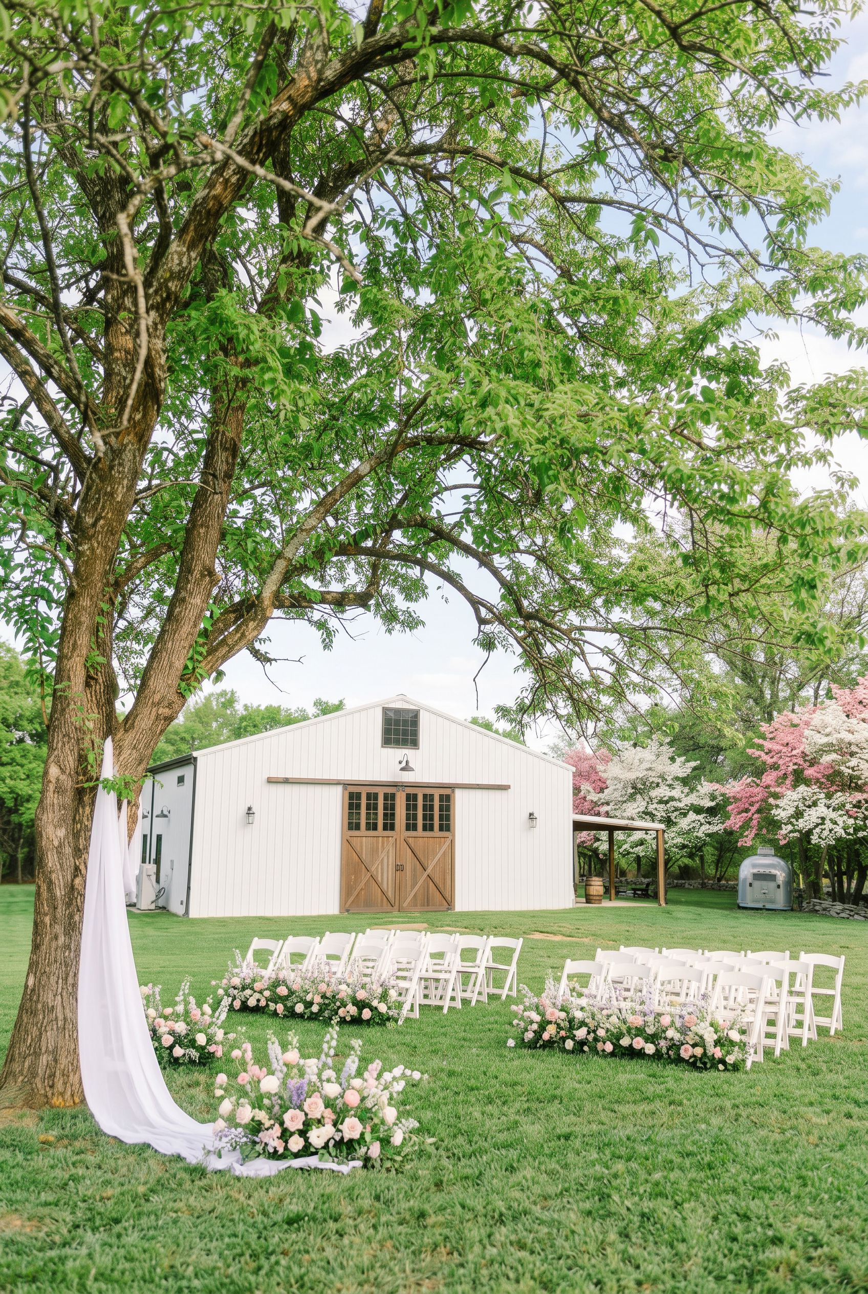 Spring ceremony on the lawn with blossoming trees and pastel florals